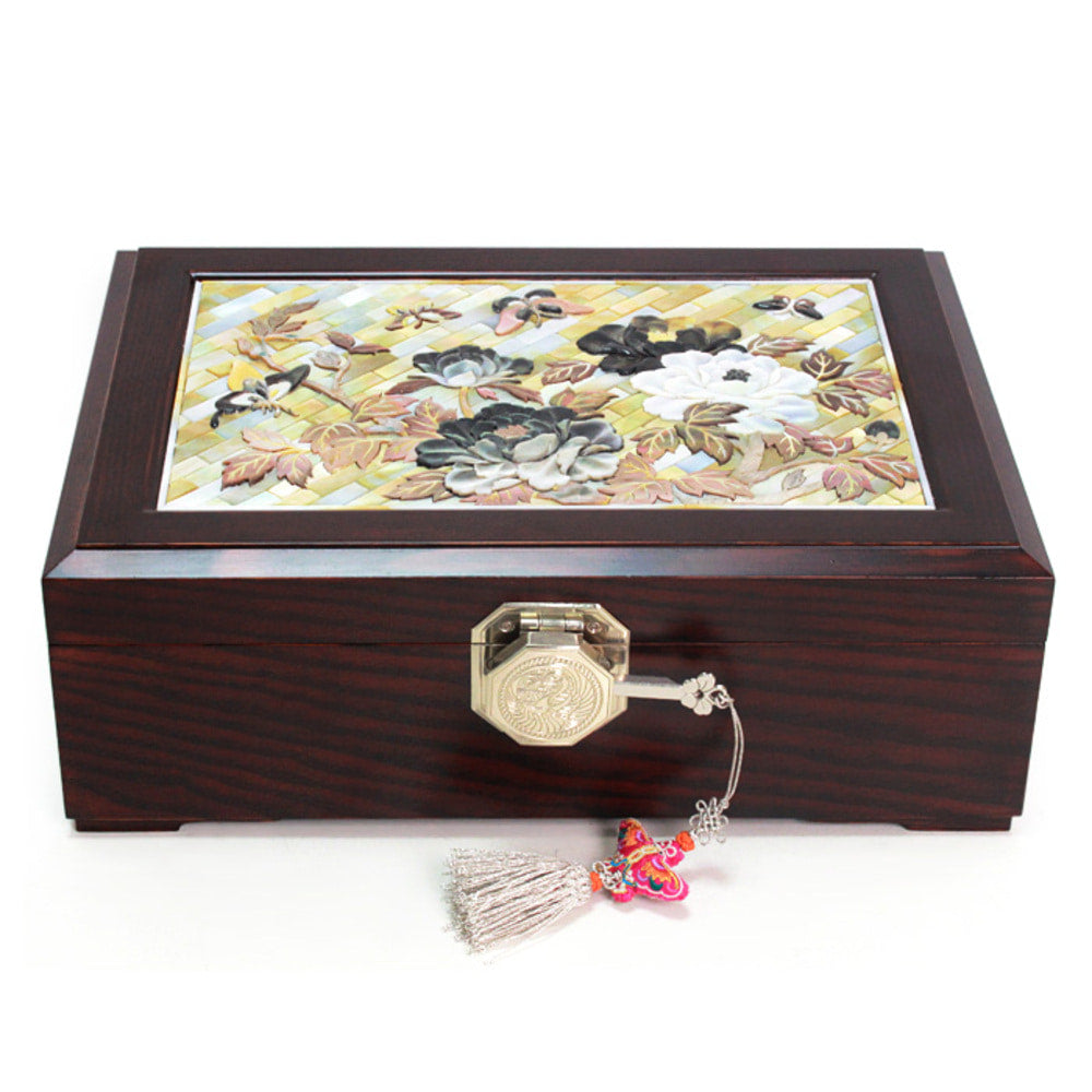 Dark rosewood Korean jewelry box with a lid panel of carved mother-of-pearl peonies and leaves over a lattice of shell strips, gilt octagonal clasp and silk tassel