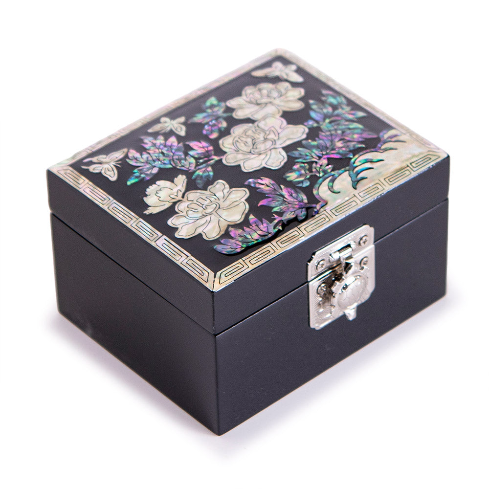 Detail of hand-cut mother-of-pearl peony and butterfly inlay on black lacquer